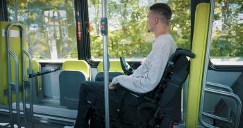 Personne en fauteuil roulant installée dans un autobus du RTC à l'espace réservé pour elle.