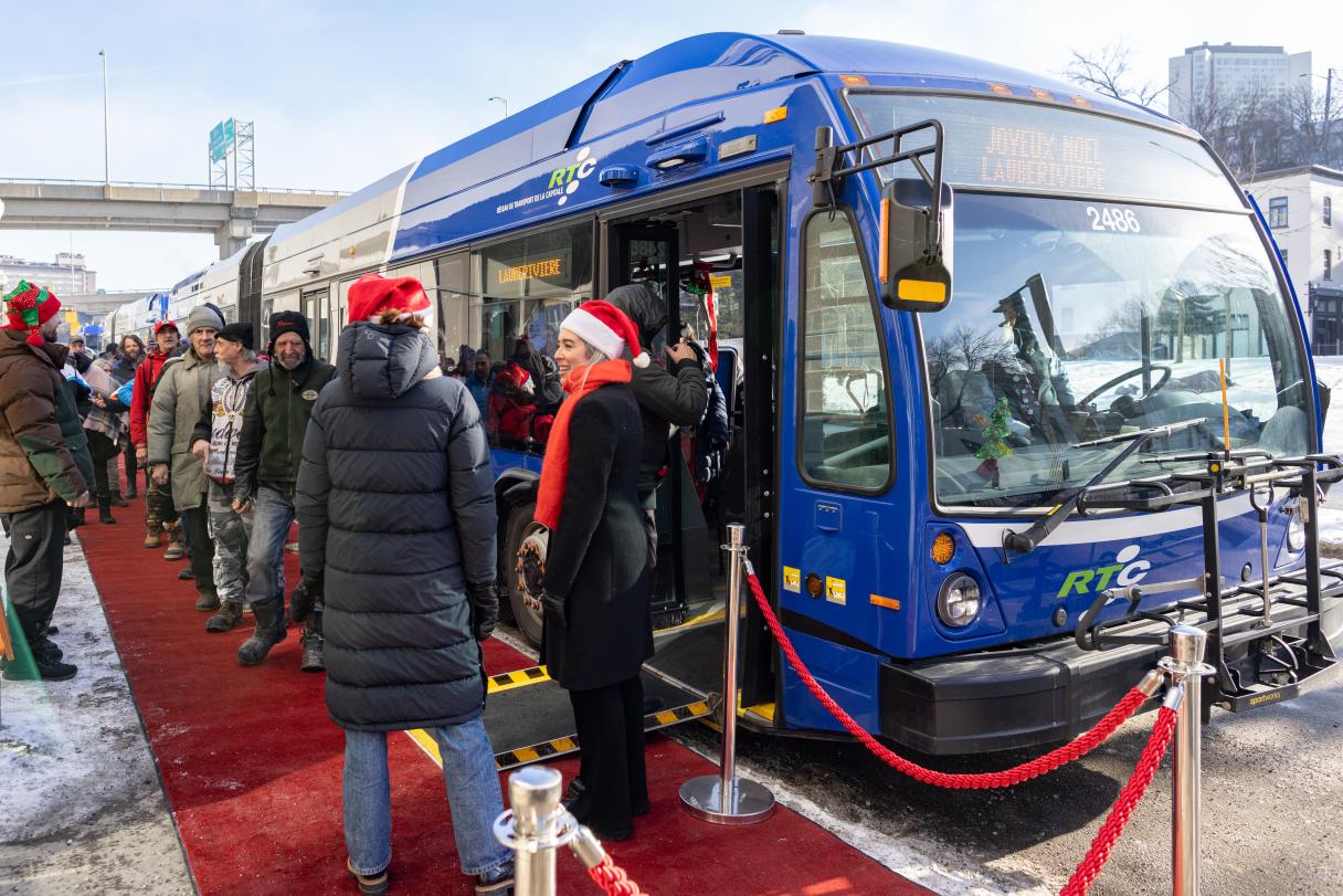 Les personnes de Lauberivière montent dans un autobus du RTC, où Madame Maude Mercier-Larouche, présidente du RTC, les accueille. 