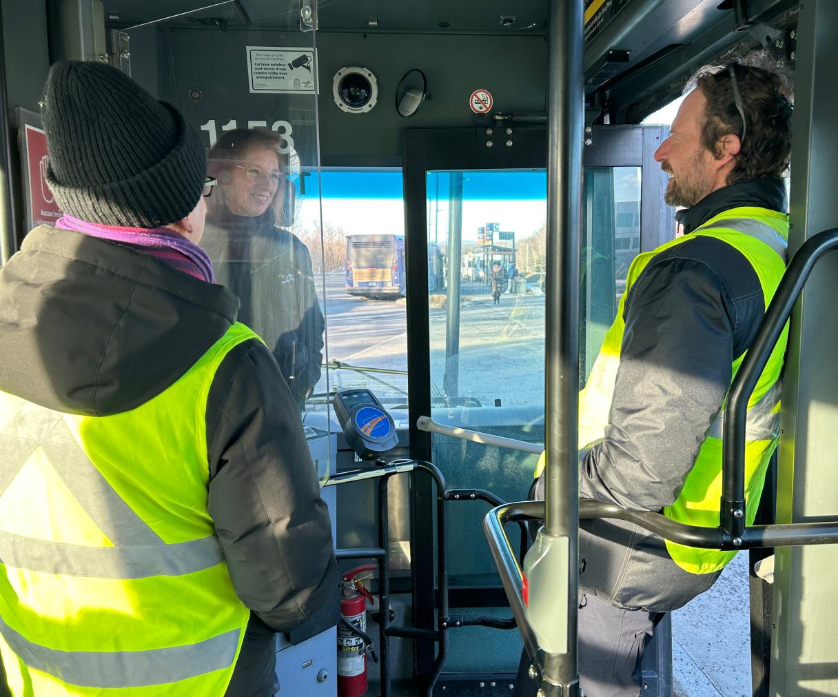 Deux gestionnaires du RTC discutent avec une chauffeure dans un bus 