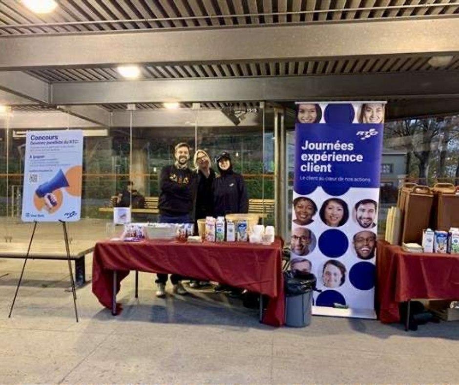 Des employés du RTC sourient à un kiosque.